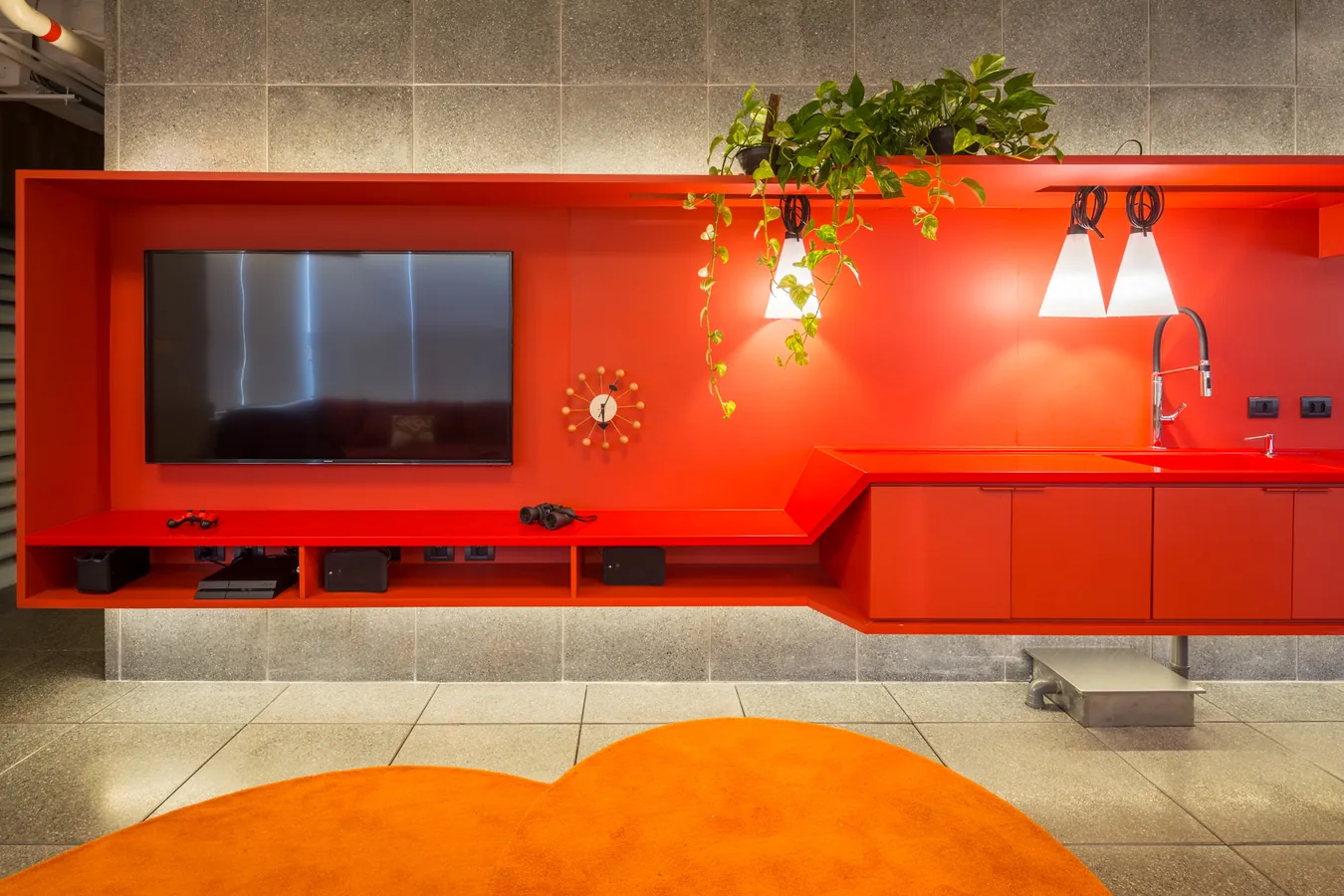Lounge com TV e parede laranja